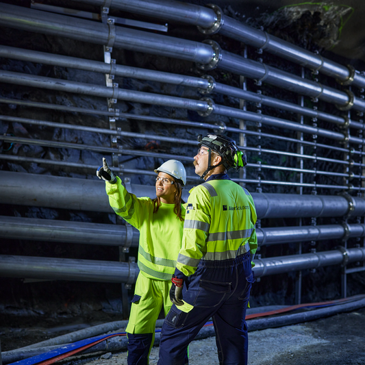 Man and woman inspect a hydropower installation